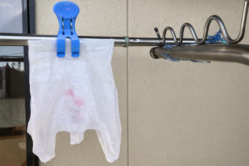 비닐봉지를 거꾸로 뒤집어 손잡이 부분이 아래로 향하게 한다.